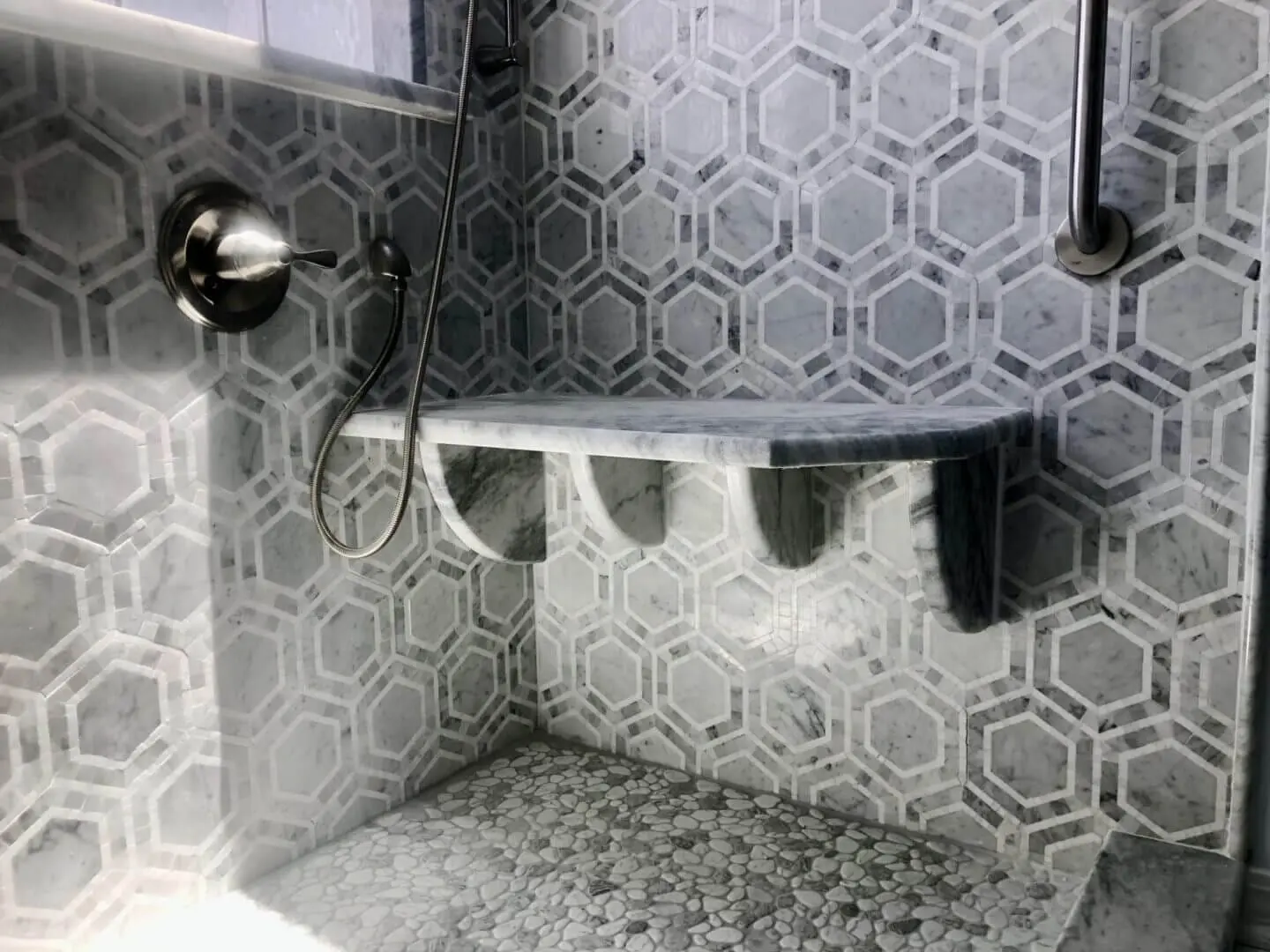 Gulf Shores shower with marble hexagon tile and built-in bench.