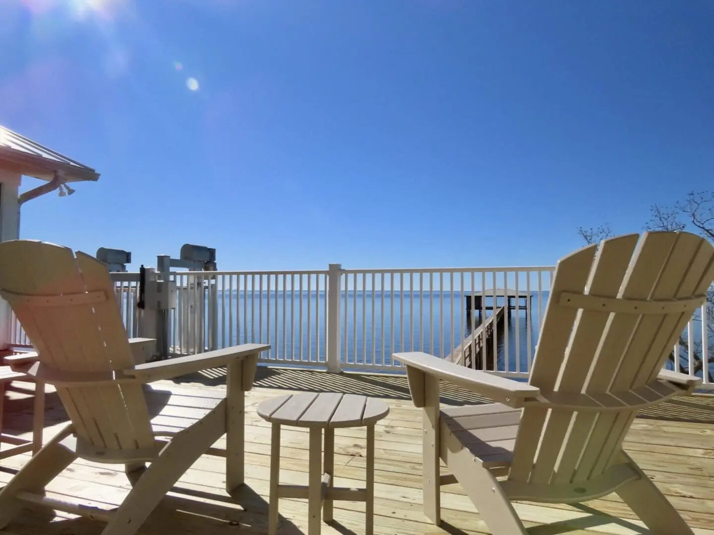 Waterfront deck with Adirondack chairs overlooking a private dock